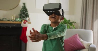 VR kulaklık takan ve Noel zamanı eğlenen mutlu Afro-Amerikan çocuk animasyonu. Noel, şenlik ve iletişim teknolojisi.