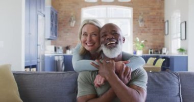 Melez yaşlı çift portresi. Birbirlerine sarılıyorlar ve evde gülümsüyorlar. emekli çift yaşam tarzı konsepti