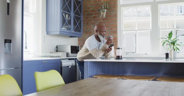 Uomo Afroamericano Senior Uomo Bere Caffè Utilizzando Smartphone Casa Pensionamento — Video Stock