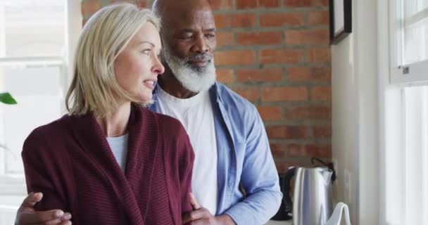 Heureux Couple Diversifié Senior Dans Cuisine Regardant Par Fenêtre Embrassant — Video