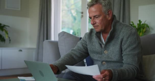 Animering Kaukasisk Senior Man Som Gör Pappersarbete Och Använder Laptop — Stockvideo