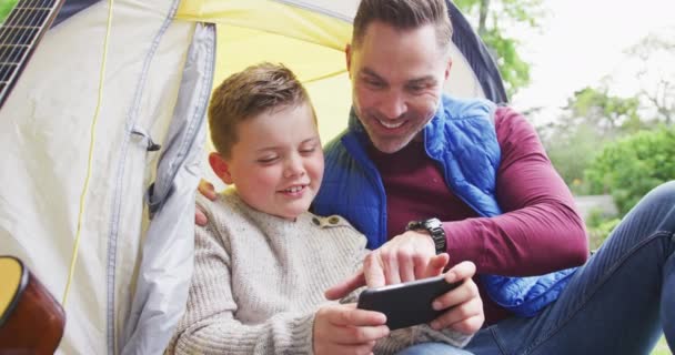 Šťastný Kavkazský Otec Synem Sedícím Stanu Používajícím Smartphone Zahradě Rodinný — Stock video