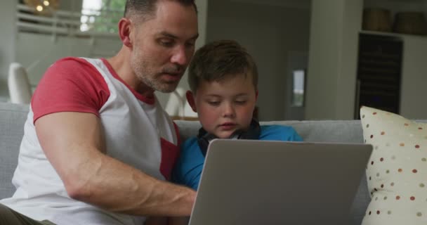 Καυκάσιος Πατέρας Γιο Που Κάθεται Στο Σαλόνι Και Χρησιμοποιεί Λάπτοπ — Αρχείο Βίντεο