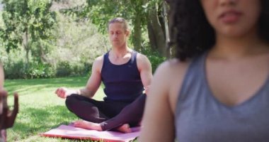 Beyaz bir adam parkta meditasyon yapıyor ve yoga yapıyor. yoga, meditasyon ve sağlıklı yaşam tarzı konsepti