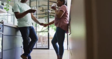 Mutlu Afro-Amerikan son sınıf çifti mutfakta şarap içiyor. emeklilik yaşam tarzı dinlenme ve evde zaman geçirme.