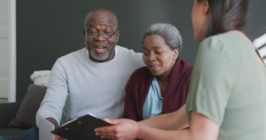 Gülümseyen Asyalı kadın danışman, Afrika kökenli Amerikalı kıdemli çifte danışmanlık yapıyor. üst düzey sağlık, destek ve yaşam tarzı.