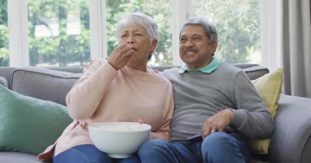 Счастливая Старшая Пара Смотрит Телевизор Попкорном Веселится Дома Отдых Пенсии — стоковое видео