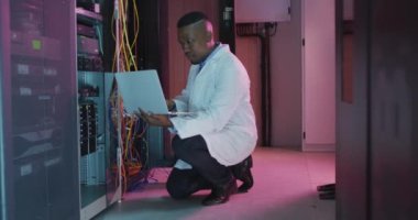 İş sunucu odasında çalışan Afrikalı Amerikalı erkek bilgisayar teknisyeni. dijital bilgi depolama ve iletişim ağı teknolojisi.