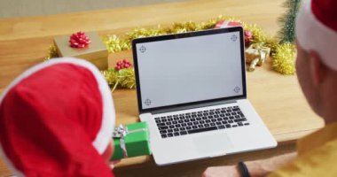 Baba ve iki oğulun Noel 'de bilgisayarda fotokopi uzayıyla görüntülenmiş görüntüsü. Noel zamanı covid 19 salgınında sosyal mesafeler