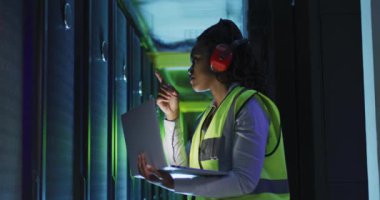 İş sunucu odasında çalışan Afrikalı Amerikalı kadın bilgisayar teknisyeni. dijital bilgi depolama ve iletişim ağı teknolojisi.