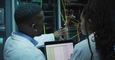 Afro-Amerikan bilgisayar teknisyenleri iş sunucu odasında tablet kullanıyorlar. dijital bilgi depolama ve iletişim ağı teknolojisi.