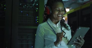 İş sunucu odasında tablet kullanan Afrikalı Amerikalı kadın bilgisayar teknisyeni. dijital bilgi depolama ve iletişim ağı teknolojisi.