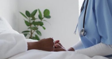 Afrika kökenli Amerikalı kadın doktor, yaşlı kadın hastayı tutuyor. covid 19 salgını sırasında üst düzey sağlık, destek ve yaşam tarzı.