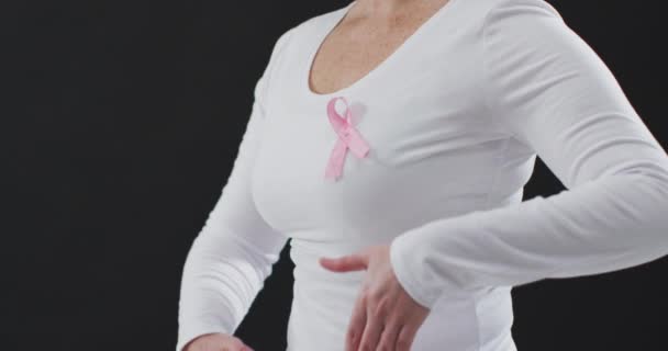 Μεσαίο Τμήμα Μιας Γυναίκας Που Δείχνει Ροζ Κορδέλα Στο Στήθος — Αρχείο Βίντεο