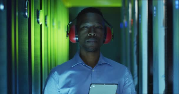 非裔美国男性计算机技师使用平板电脑在商业服务器室工作 数字信息存储和通信网络技术 — 图库视频影像