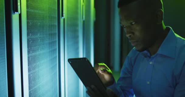 非裔美国男性计算机技师使用平板电脑在商业服务器室工作 数字信息存储和通信网络技术 — 图库视频影像