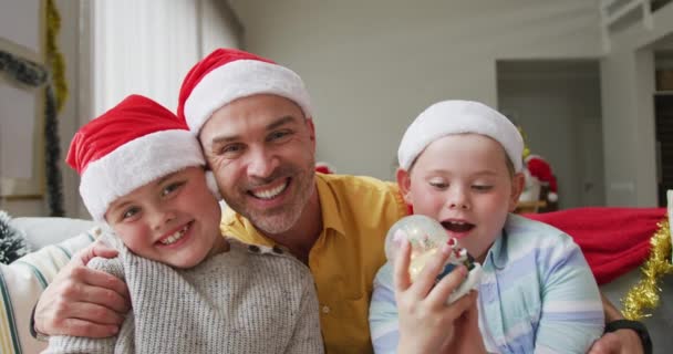 아버지와 모자를 소파에 미소짓고 아들의 크리스마스 축하와 축하의 — 비디오