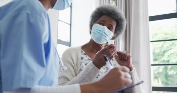 Afroamerikansk Kvinnlig Läkare Och Kvinnlig Patient Ansiktsmasker Seniorvård Stöd Och — Stockvideo