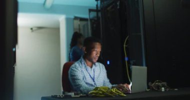 İş sunucu odasında çalışan Afrikalı Amerikalı erkek bilgisayar teknisyeni. dijital bilgi depolama ve iletişim ağı teknolojisi.