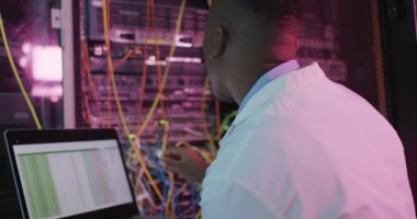 İş sunucu odasında çalışan Afrikalı Amerikalı erkek bilgisayar teknisyeni. dijital bilgi depolama ve iletişim ağı teknolojisi.