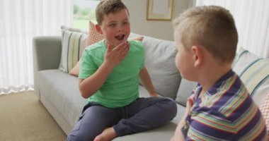 İki Kafkas kardeş evdeki kanepede otururken göğüslerini birbirine vuruyorlar. Kardeşlik ve aşk kavramı