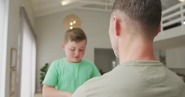 白人の少年は自宅のリビングルームで父親を抱きかかえていた 父親と愛の概念 — ストック動画