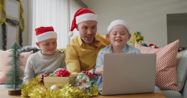 아버지와 아들은 모자를 크리스마스에 노트북으로 비디오를 찍었습니다 크리스마스에 세계적 유행병 — 비디오