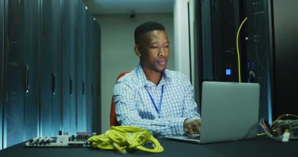 在商业服务器室工作的非裔美国男性计算机技师笔记本电脑 数字信息存储和通信网络技术 — 图库视频影像