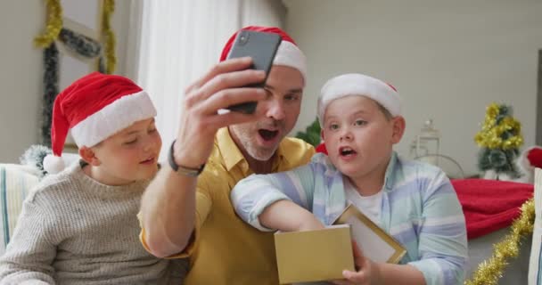 Padre Caucásico Dos Hijos Abren Regalos Mientras Tienen Videocall Teléfono — Vídeos de Stock