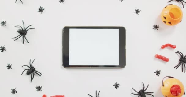 在灰色背景的南瓜印刷桶 蜘蛛玩具和数字平板电脑之间的可怕的糖果 假日与庆祝概念之间的距离 — 图库视频影像