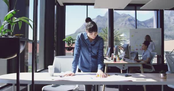 忙しい現代建築事務所で働く白人実業家の正面図彼女の机で計画を見て スローモーション — ストック動画