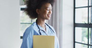 Boynunda steteskop olan gülümseyen Afrikalı Amerikalı kadın doktor portresi. üst düzey sağlık, destek ve yaşam tarzı.