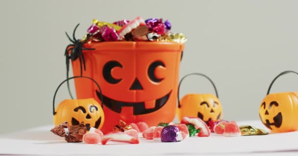 Cubo Estampado Calabaza Halloween Aterrador Lleno Caramelos Sobre Fondo Gris — Vídeo de stock