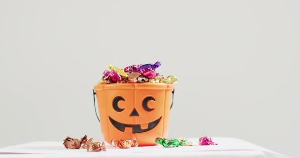 Cubo Estampado Calabaza Halloween Aterrador Lleno Caramelos Sobre Fondo Gris — Vídeos de Stock