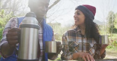 Gülümseyen çeşitli çiftler çay içip kırsalda yürüyüş yapıyorlar. sağlıklı, aktif yaşam tarzı ve boş zaman.