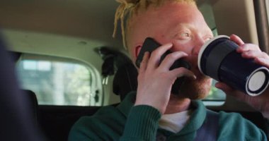 Afrika kökenli mutlu bir Amerikalı adam. Arabada oturmuş akıllı telefondan konuşuyor. Dijital göçebe şehirde geziyor, dolaşıyor..