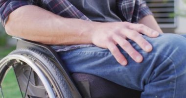 Sokakta tekerlekli sandalyedeki beyaz engelli adama yakın durun. fiziksel engelli ev hayatı.