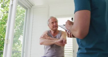 Beyaz, üst düzey bir adam açıklarken erkek eğitmen not alıyor. Yaşlıların sağlık ve iletişim hizmetleri.