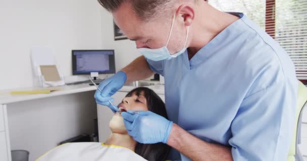 Kavkazský Zubař Obličejovou Maskou Vyšetřující Zuby Pacientky Moderní Zubní Klinice — Stock video