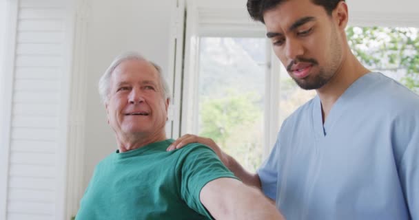 Fisioterapeuta Masculino Rotando Mano Del Anciano Jubilado Sentido Las Agujas — Vídeo de stock