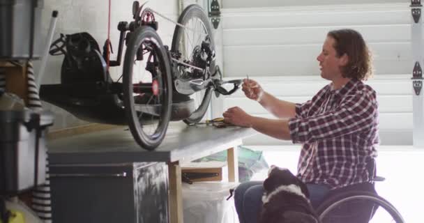 Επικεντρωμένος Καυκάσιος Ανάπηρος Αναπηρικό Αμαξίδιο Επισκευάζει Ποδήλατο Στο Γκαράζ Οικιακή — Αρχείο Βίντεο