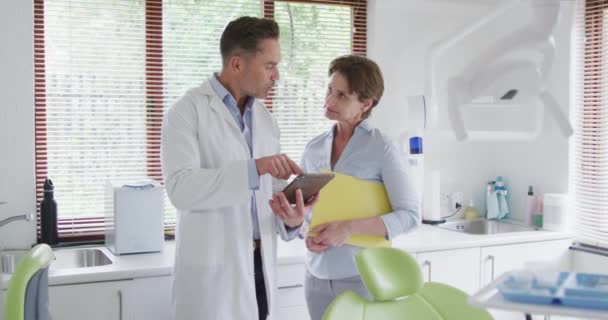 Biały Dentysta Rozmawia Białą Pielęgniarką Dentystyczną Nowoczesnej Klinice Dentystycznej Działalność — Wideo stockowe