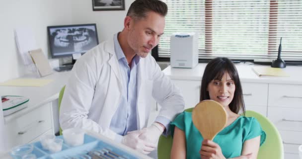 Uśmiechnięty Biały Dentysta Rozmawiający Pacjentką Nowoczesnej Klinice Dentystycznej Działalność Zakresie — Wideo stockowe