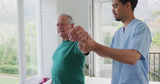 Biracial Fisioterapeuta Masculino Retardando Mão Movimento Homem Idoso Rimando Com — Vídeo de Stock