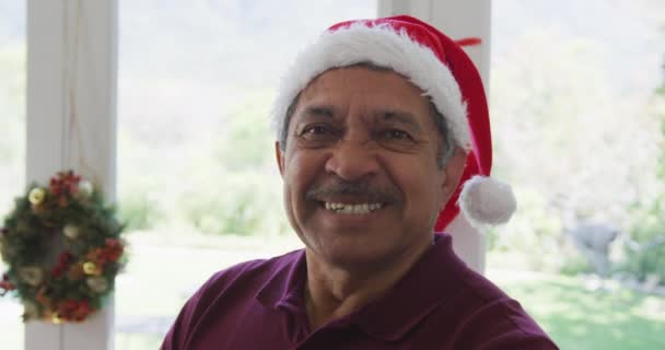 圣诞期间 在装饰过的家中 一个头戴圣诞礼帽的快乐老人的画像 圣诞节 节日和家庭生活方式 — 图库视频影像