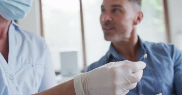 Enfermeira Dentista Branca Com Máscara Facial Examinando Dentes Paciente Masculino — Vídeo de Stock