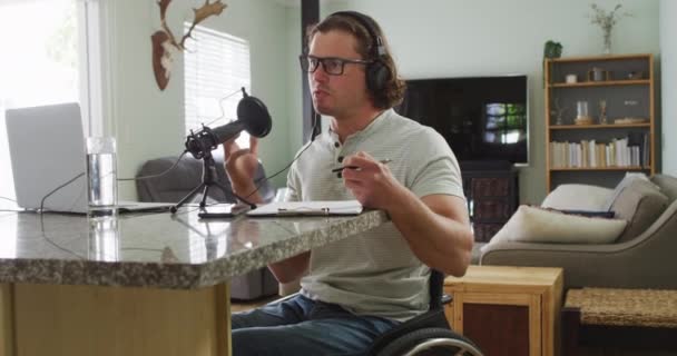Soustředěný Invalidní Běloch Invalidním Vozíku Nosí Sluchátka Nahrává Píše Poznámky — Stock video