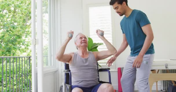 Birasowy Trener Pomagający Niepełnosprawnemu Starszemu Mężczyźnie Ćwiczyć Hantlami Studio Fitness — Wideo stockowe