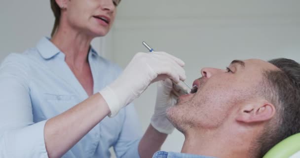 Enfermera Dental Caucásica Examinando Los Dientes Paciente Masculino Una Clínica — Vídeos de Stock