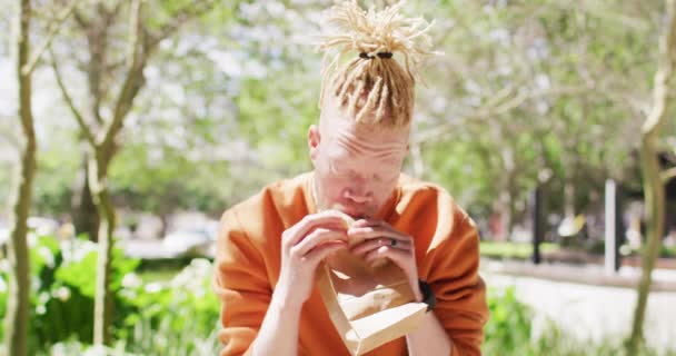 Albino African American Dreadlocks Stând Parc Bicicleta Mananca Sandwich Drum — Videoclip de stoc